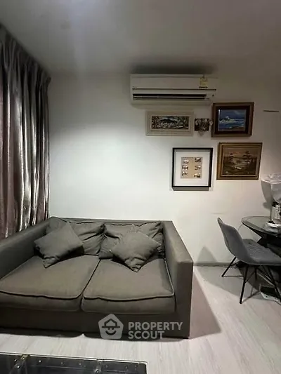 Cozy living room with modern sofa and wall art, perfect for relaxation.