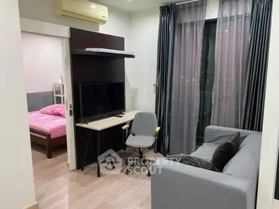 Modern apartment living room with TV, sofa, and bedroom view.