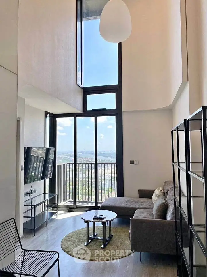Modern living room with high ceiling and stunning city view from balcony.