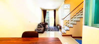 Spacious living room with modern staircase and cozy seating area, perfect for family gatherings.