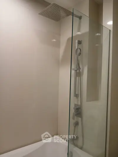 Modern bathroom with sleek shower and glass partition in a contemporary apartment.