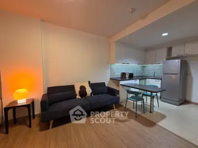 Modern open-plan living room with cozy sofa and stylish kitchen area.