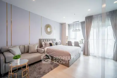 Modern bedroom with stylish decor and large windows offering natural light