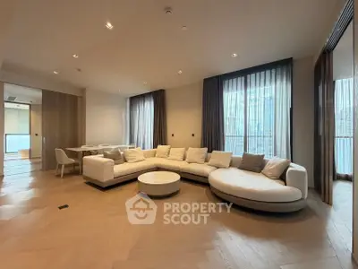 Spacious modern living room with elegant curved sofa and large windows