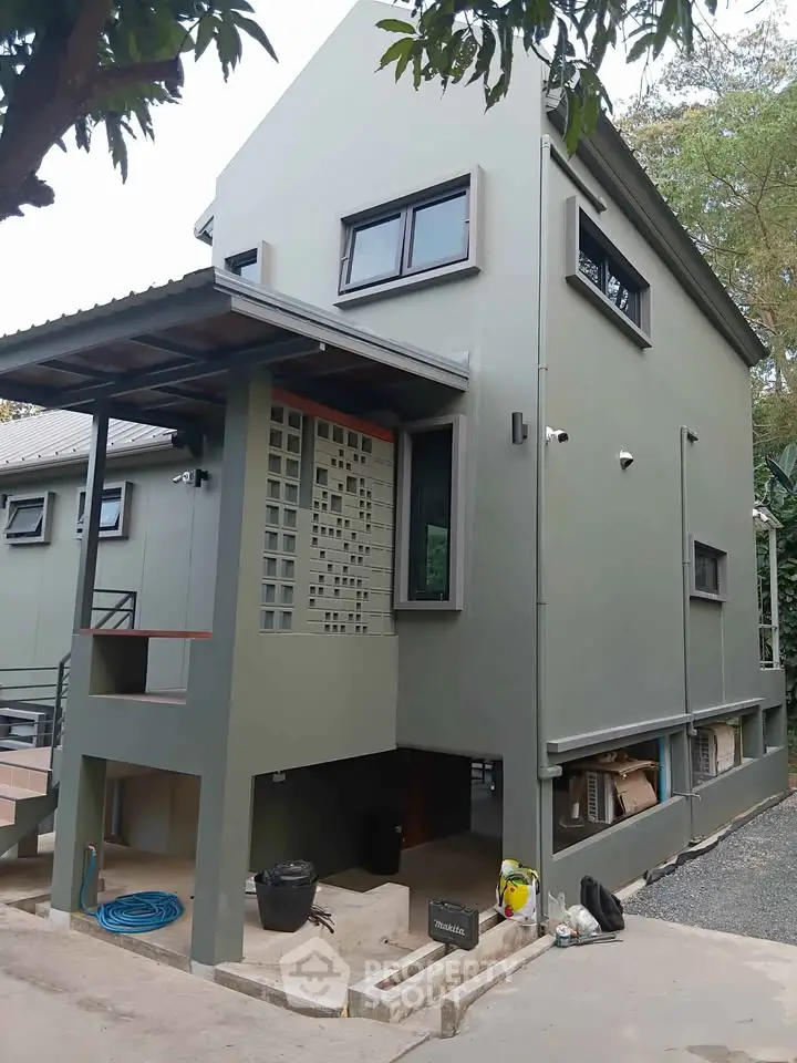 Modern two-story house with unique architectural design and spacious outdoor area.