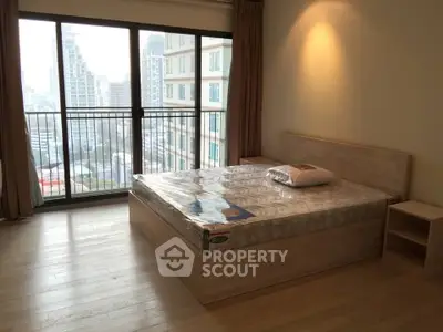 Spacious bedroom with city view and large window in modern apartment