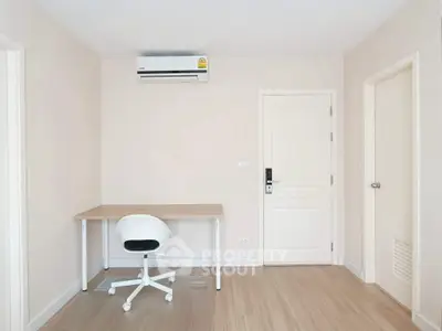 Minimalist study room with desk, chair, and air conditioning in modern apartment.