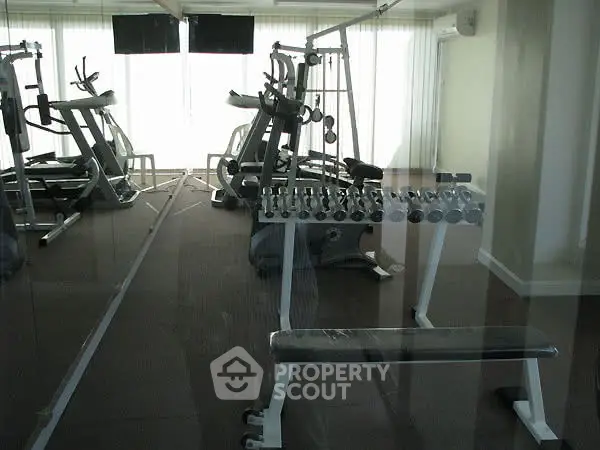 Modern gym with state-of-the-art fitness equipment and natural lighting.