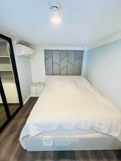 Cozy bedroom with modern design and ample storage space, featuring a comfortable bed and sleek flooring.
