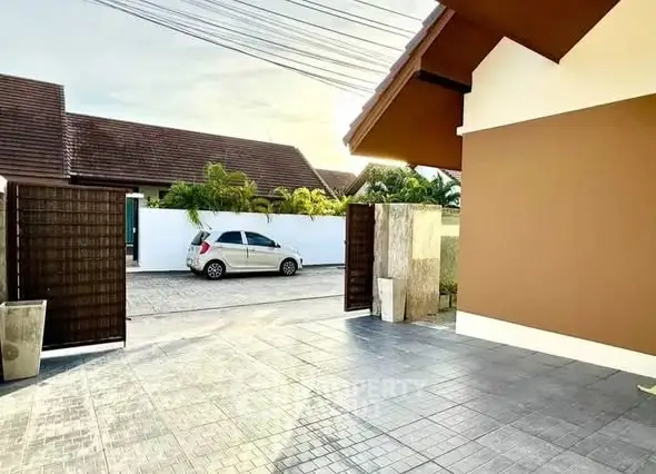 Spacious driveway with modern gate and car parked outside, perfect for easy access and security.