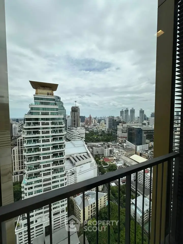 Stunning cityscape view from a high-rise balcony showcasing modern architecture and lush greenery.