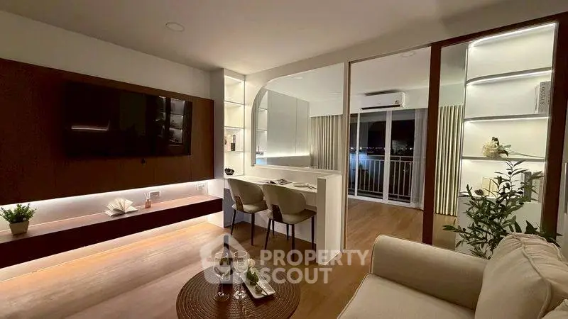 Modern living room with stylish decor and balcony view, featuring elegant lighting and cozy seating area.