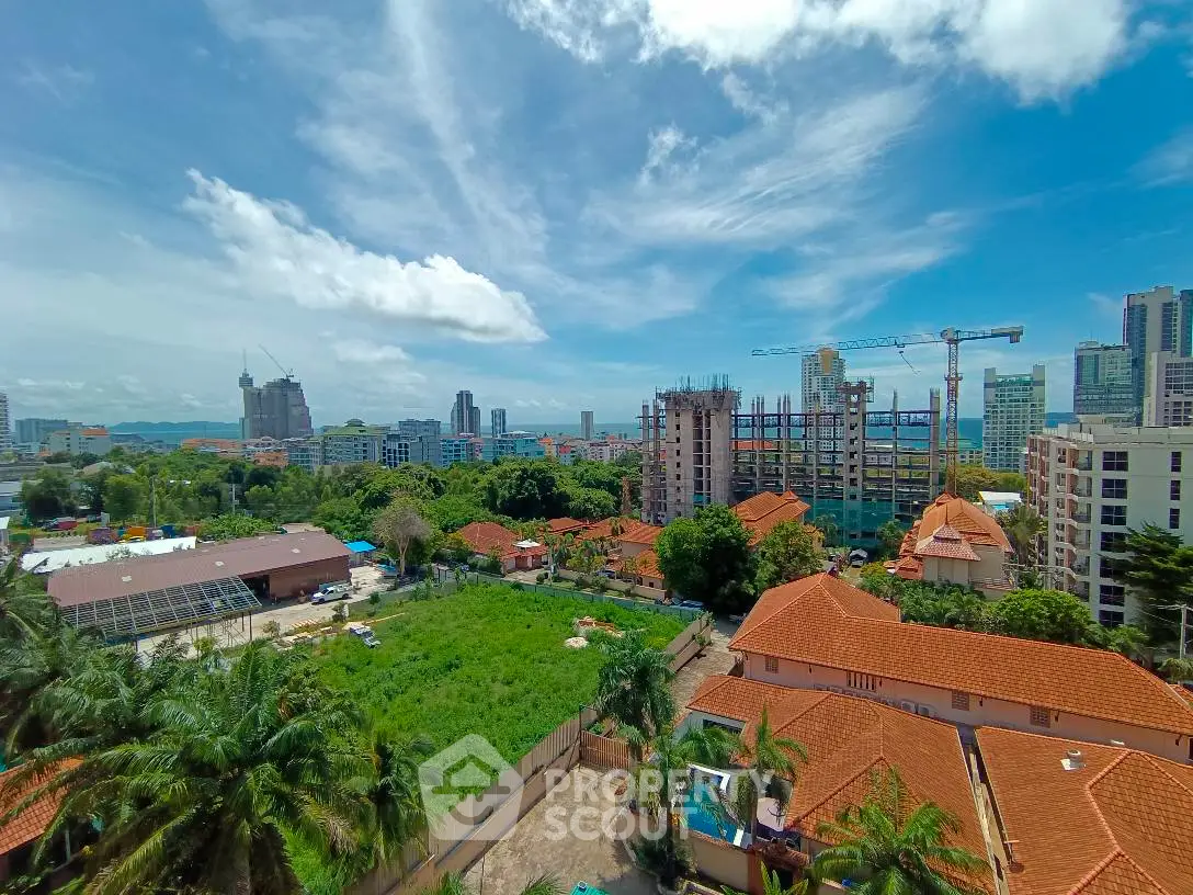 Stunning cityscape view with lush greenery and modern high-rise buildings under a clear blue sky.