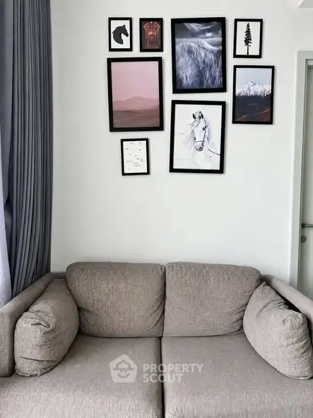 Stylish living room with cozy sofa and modern art gallery wall, perfect for relaxation and entertaining.