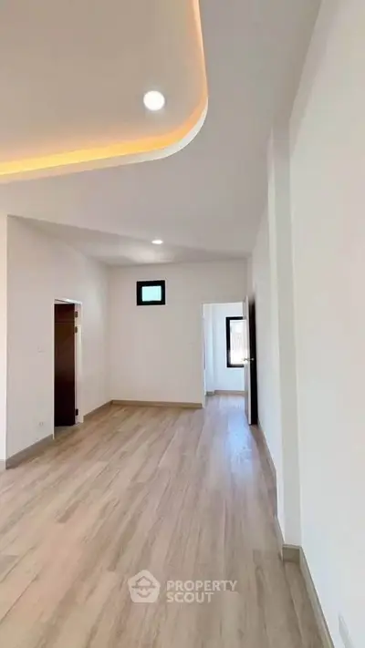 Spacious modern interior with elegant wood flooring and recessed lighting, perfect for contemporary living.