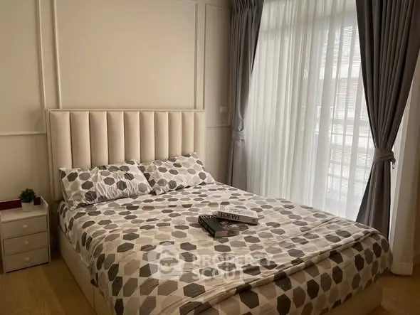 Cozy bedroom with modern decor and large window for natural light.