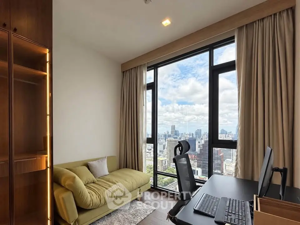 Modern study room with city view, featuring a cozy sofa and sleek desk setup.