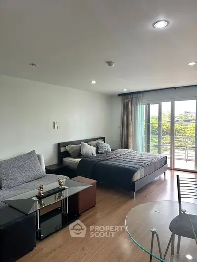 Spacious modern bedroom with balcony and stylish furnishings, perfect for urban living.