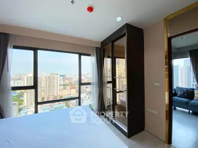 Modern bedroom with stunning city view and large windows in high-rise apartment.