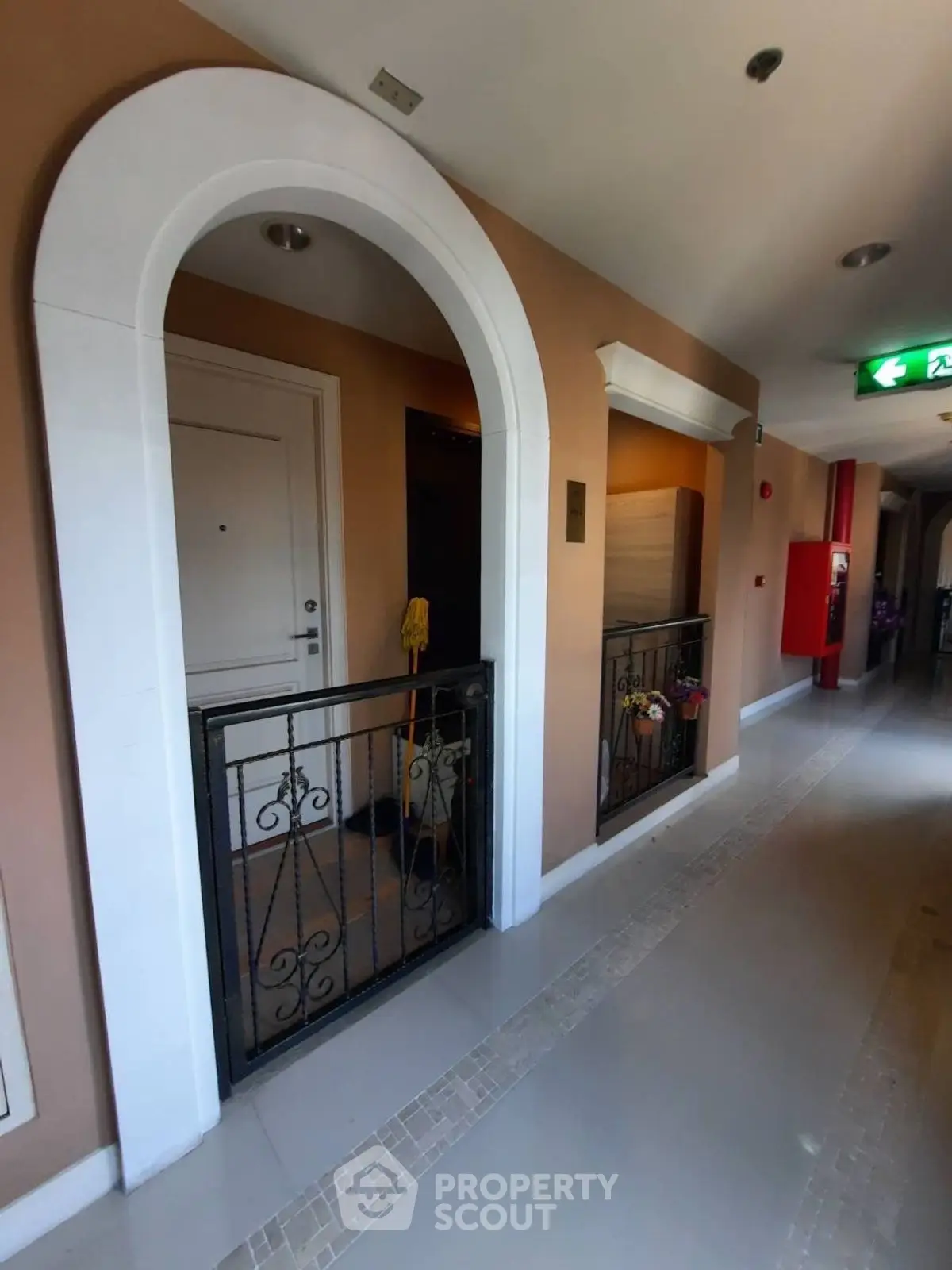 Elegant apartment entrance with stylish archway and secure iron gate