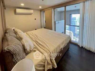 Luxurious bedroom with city view and modern decor in high-rise apartment.
