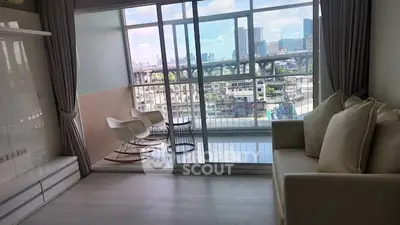 Modern living room with large balcony and stunning city view, featuring cozy seating and sleek design.