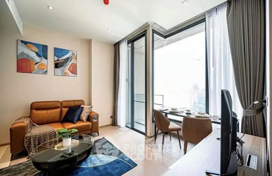 Modern living room with stylish decor and large windows offering city views.