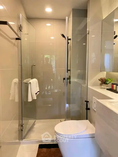 Modern bathroom with glass shower and sleek fixtures in luxury home.