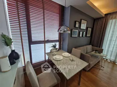 Modern living room with dining area, stylish decor, and natural light through large windows.