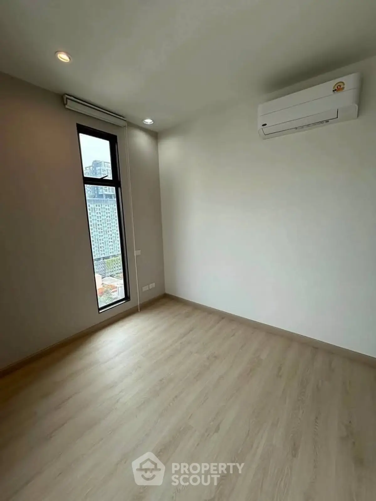 Bright empty room with large window and air conditioning, perfect for customization.