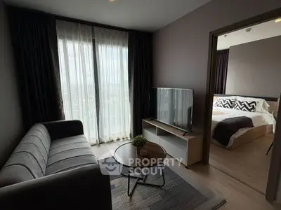 Modern living room with cozy sofa and TV, adjacent to stylish bedroom.