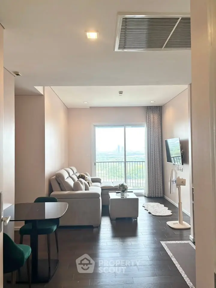 Modern living room with stylish decor and large window offering scenic views.