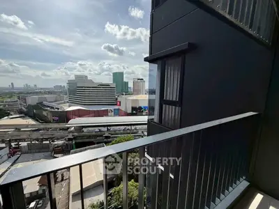 Stunning urban view from a modern balcony overlooking cityscape and shopping center.