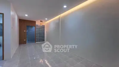 Spacious modern living room with sleek tile flooring and ambient lighting