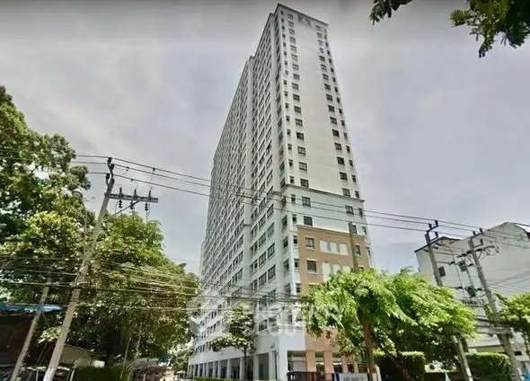 High-rise residential building with lush greenery and clear sky view