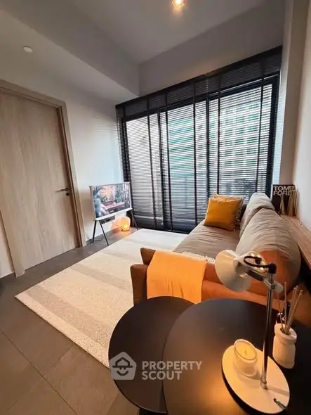 Modern living room with stylish decor and large windows offering natural light.