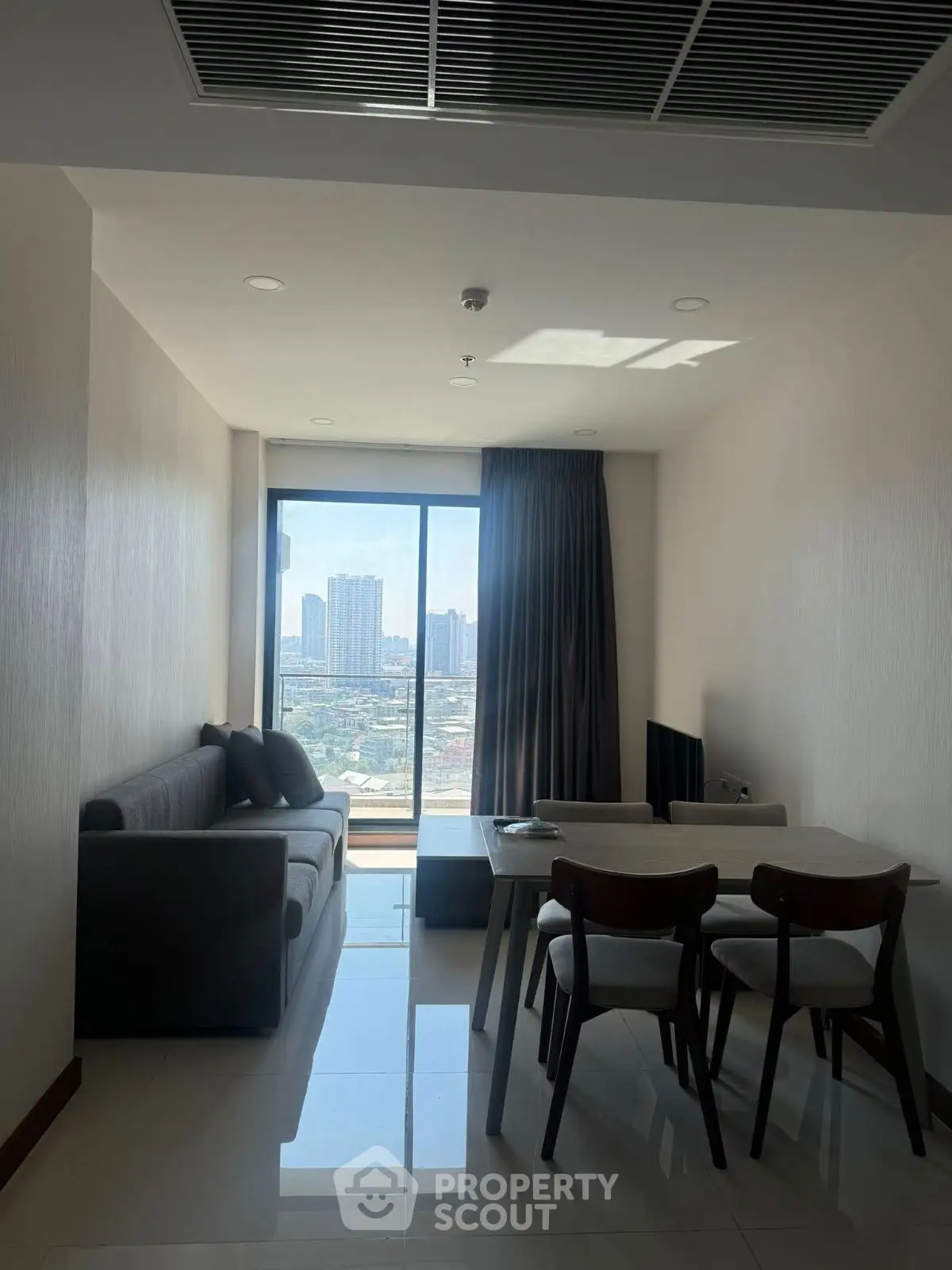 Modern living room with city view, sleek furniture, and natural light