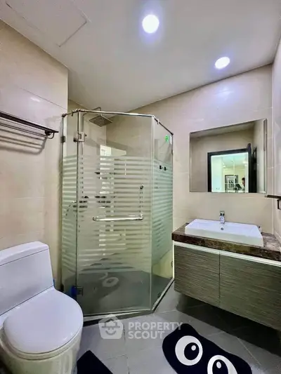 Modern bathroom with glass shower, sleek vanity, and stylish decor