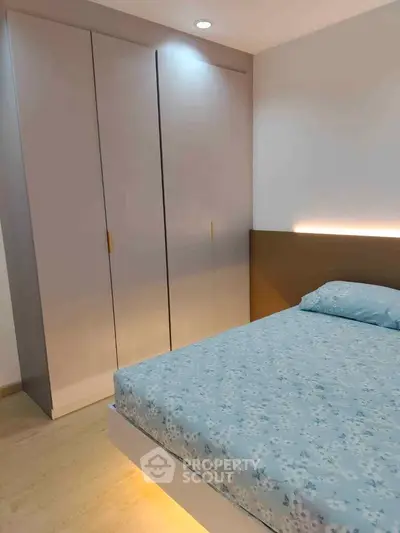 Modern bedroom with sleek wardrobe and cozy bed in stylish apartment.