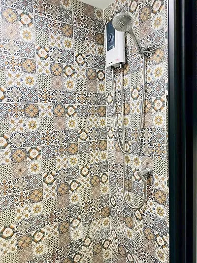 Stylish bathroom with intricate patterned tiles and modern shower fixture.