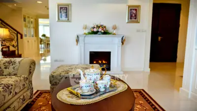 Elegant living room with classic fireplace and floral tea set, perfect for cozy gatherings.