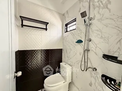 Modern bathroom with stylish black and white tiles and sleek shower fixtures.