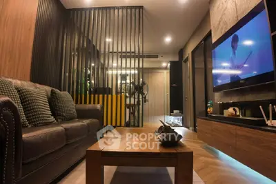 Modern living room with stylish decor and large TV, perfect for relaxation.