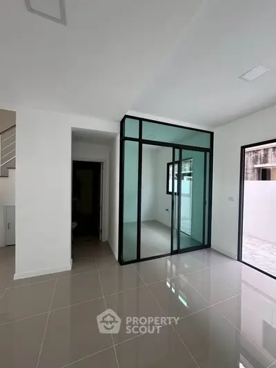 Modern minimalist interior with glass partition and sleek tile flooring