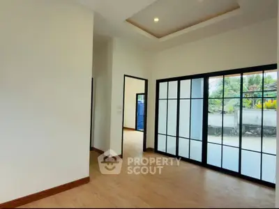 Spacious modern interior with large windows and wooden flooring, perfect for natural light lovers.