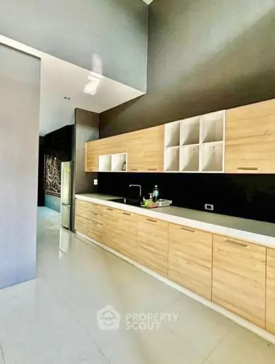 Modern kitchen with sleek wooden cabinets and high ceiling design