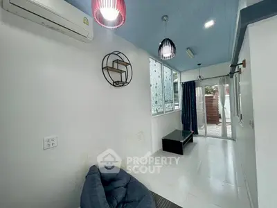 Cozy living room with modern lighting and large windows for natural light