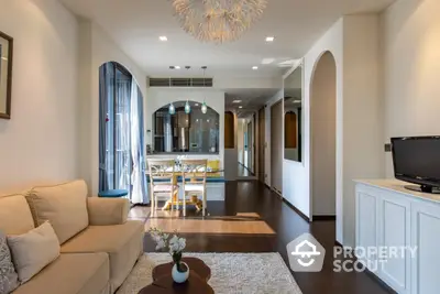 Elegant open-plan living space with gleaming hardwood floors, modern furniture, and a seamless transition to a well-lit dining area, perfect for entertaining.