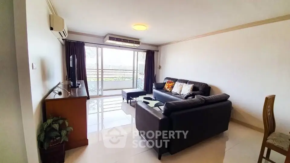 Spacious living room with modern furniture and balcony view