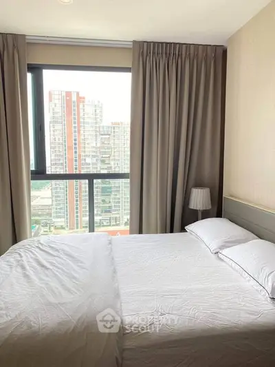 Modern bedroom with large window offering city view in high-rise apartment
